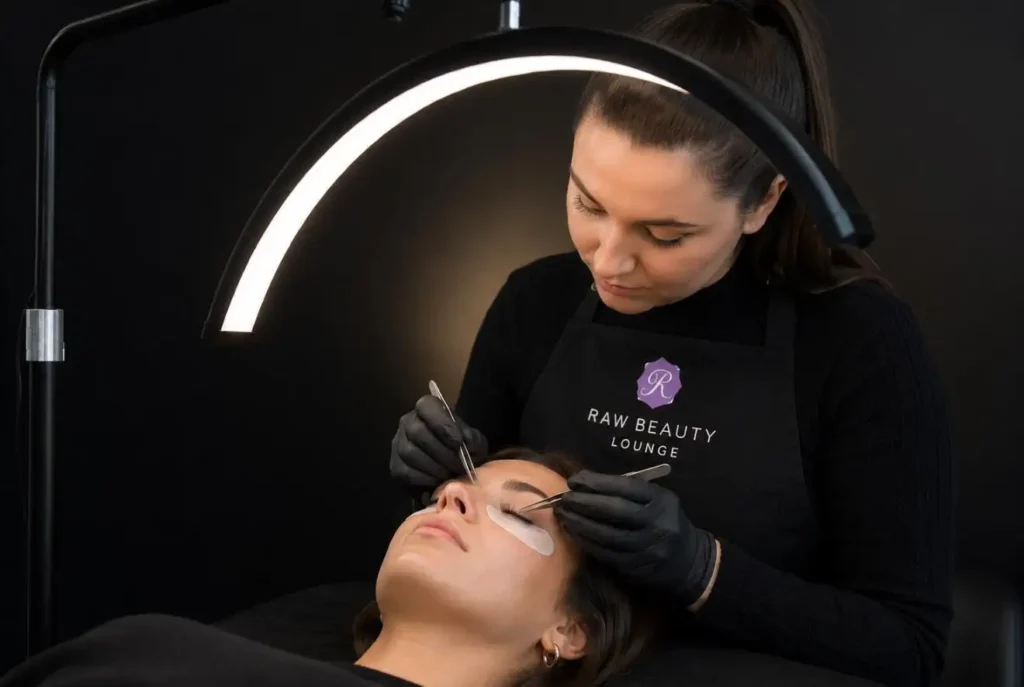 lash-salon Lash artist applying extensions under a ring light in Omaha